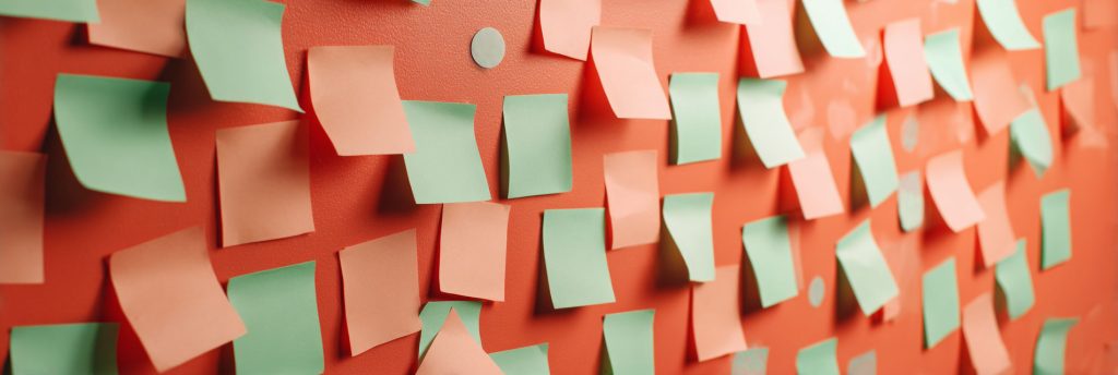 A coral wall with numerous mint green and coral paper